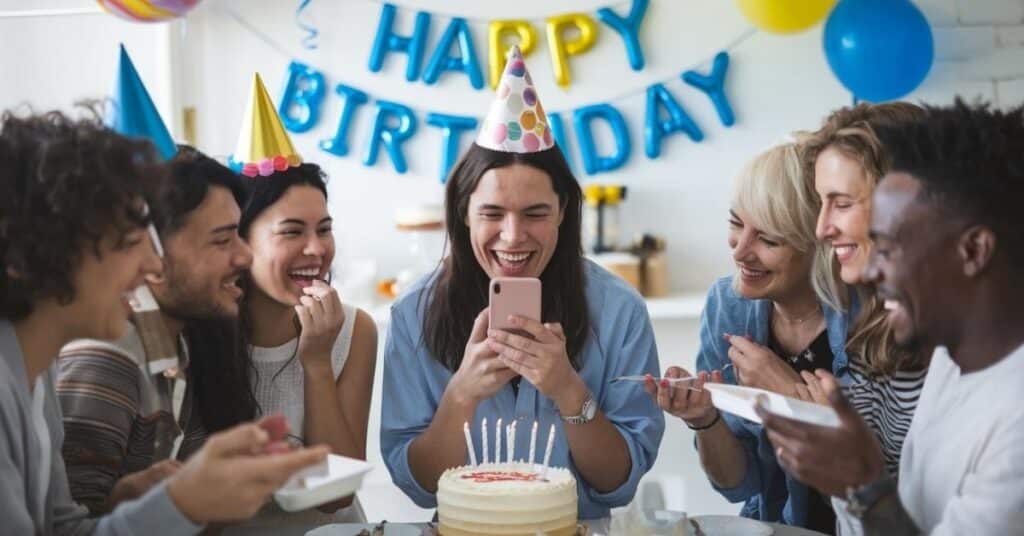 Person laughing while reading birthday messages at a fun and festive birthday party.